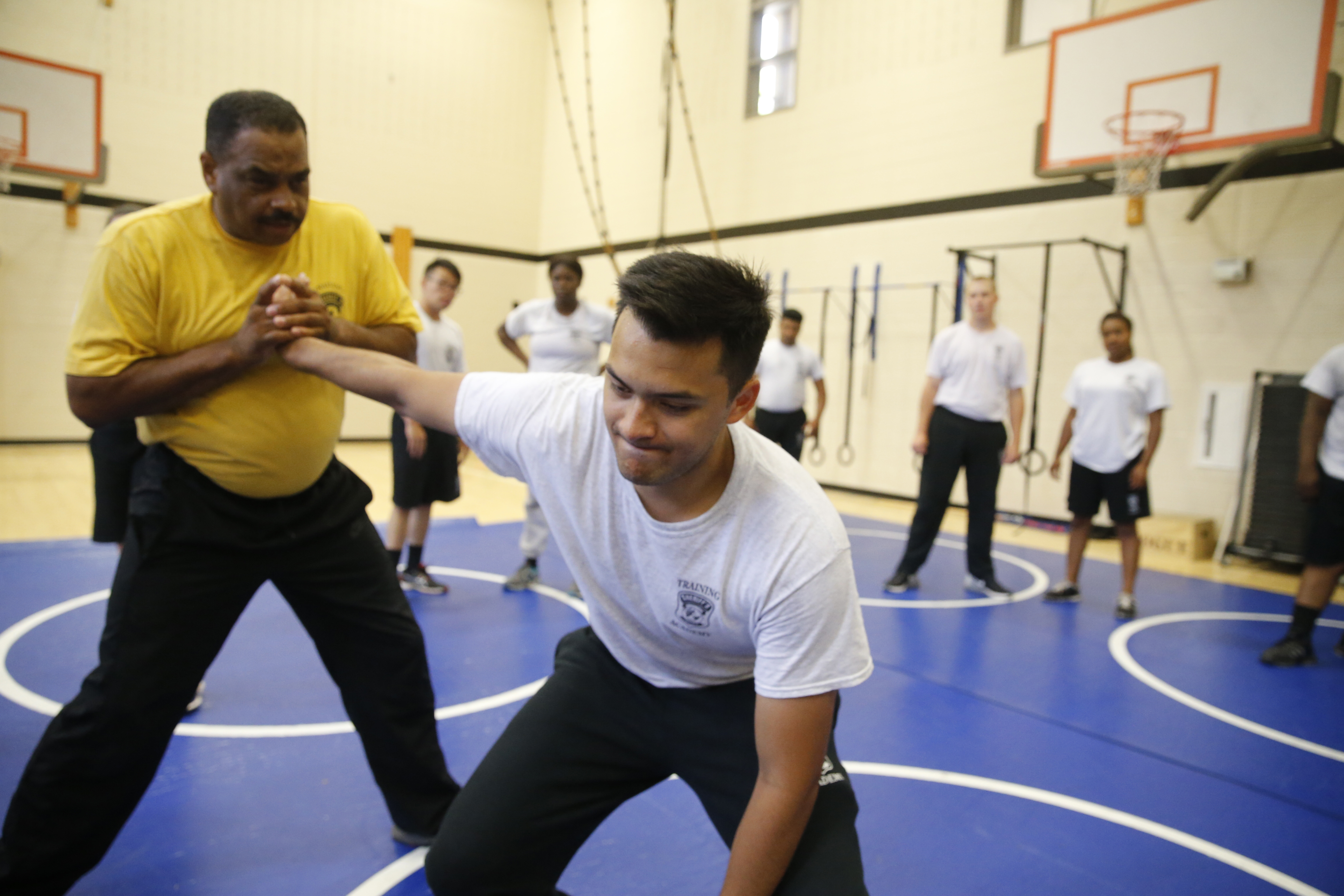 Academy recruit, Agustin Hussain, right, is subdued by Sergeant David Turner, left, during a course on the the finer points of hand-to-hand defensive techniques on July 13.